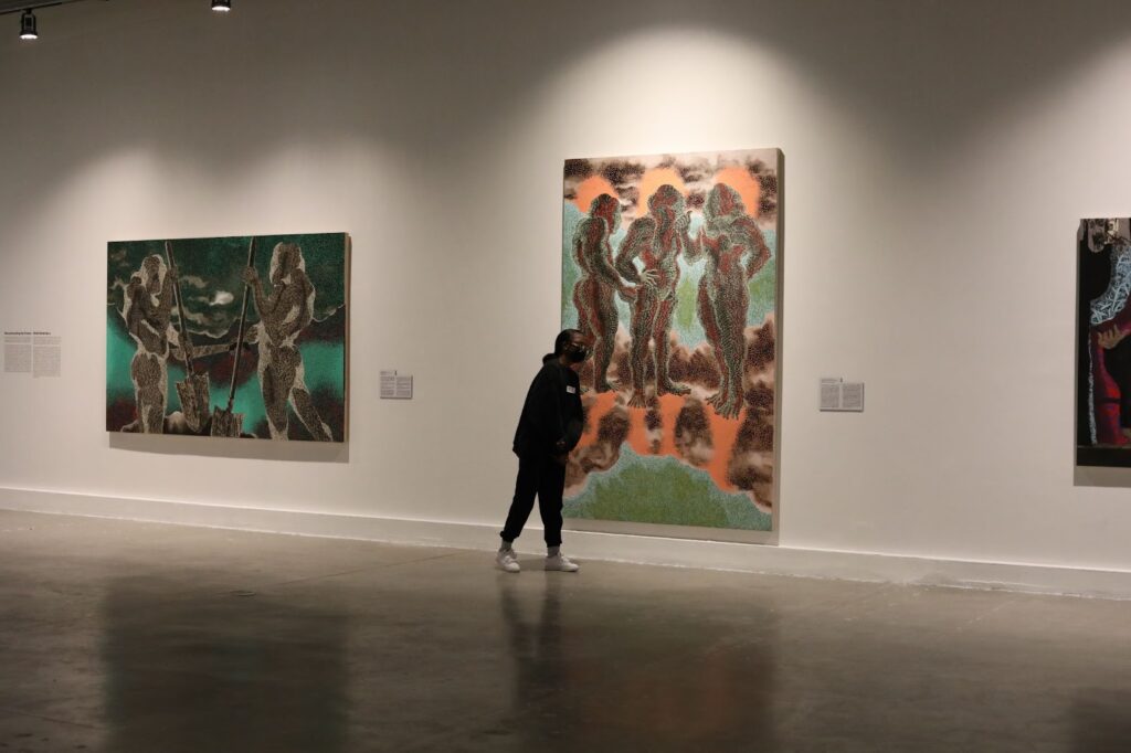 Museum / At the Museum of Contemporary Art North Miami, a visitor goes past the Didier William display. Photo by (Ashley Miznazi/ The Haitian Times)